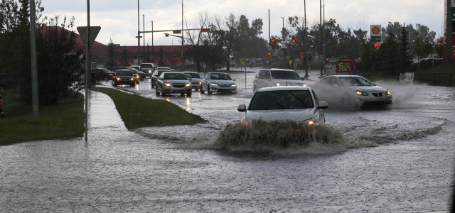 stark befahrene und teilweise überflutete Verkehrsstraße bei Starkregen