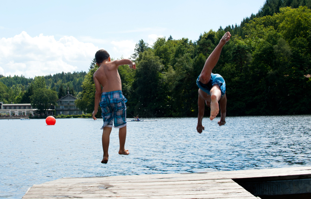 Vom Steg des Strandbades aus springen zwei Kinder ins Wasser. © view - die agentur