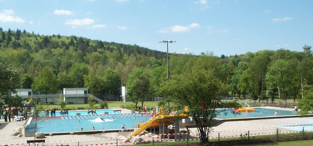 Badegäste schwimmen und planschen im Warmfreibad Kaiserslautern. 