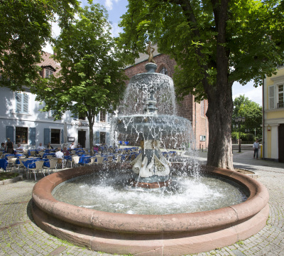 Aufnahme des Martinsbrunnen mit dem Restaurant St. Martin und der Martinskirche im Hintergrund