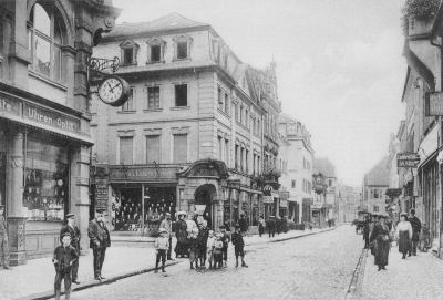 Die Marktstraße versetzt den Betrachter in das Jahr um 1890. Nicht nur die Mode der Leute, sondern auch die Bauart der Häuser mit den verspielten Fassaden lassen in ein ganz anderes Kaiserslautern blicken.