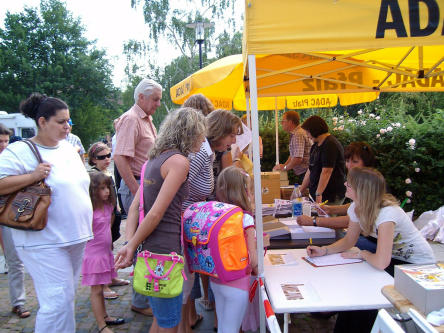 Foto zeigt ADAC-Stand mit Schriftführern und Kinder mit ihren Eltern bei der Anmeldung