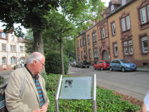 Dr. Pedro Grünstein, Sohn Hilde Mattauchs, mit Blick auf die neu installierte Gedenktafel. im Hintergrund das Haus in der Hummelstraße 3, in dem Hilde  Mattauch viele Jahre gelebt hat © Stadt Kaiserslautern