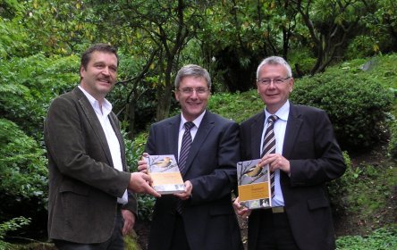 Peter Ramachers überreicht sein Werk an Landrat Paul Junker und Oberbürgermeister Dr. Klaus Weichel. © Kreisverwaltung Kaiserslautern