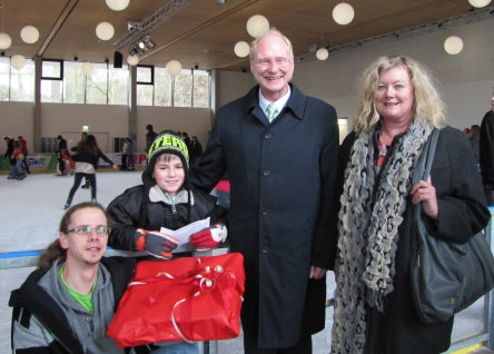 Nico Munoz Caneteh (zweite von links) ist der 25.000ste Besucher der städtischen Eisbahn. Zusammen mit seinem Bruder (links), dem Beigeordneten Joachim Färber und Karin Decker, Stadtsparkasse Kaiserslautern, freut er sich über kleine Präsente. © Stadt Kaiserslautern