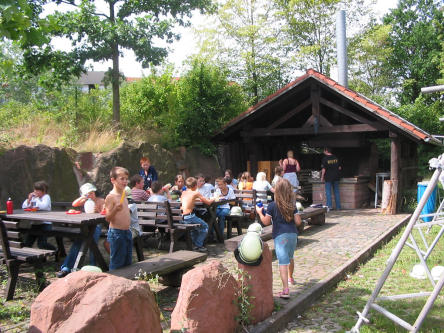 Foto zeigt Mädchen und Jungs mit Ihren Betreuern vor einer Grillhütte 