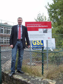 Beigeordneter Peter Kiefer bei der Aufstellung des ersten Bauschildes an der Grundschule in Morlautern