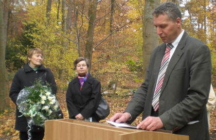 Foto zeigt den Beigeordneten der Stadt Kaiserslautern, Herrn Peter Kiefer, am Rednerpult auf dem Friedhof mit Zuhörern