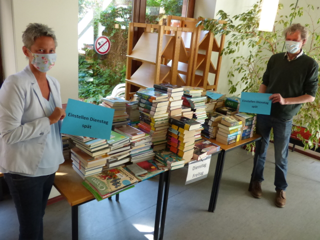 Bürgermeisterin Beate Kimmel und Franz-Josef Huschens vor einem Bücherstapel in Quarantäne.  © Stadt Kaiserslautern