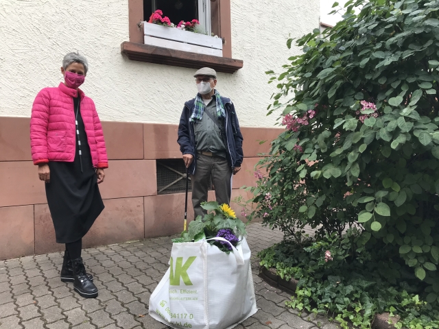 Bürgermeisterin Beate Kimmel beim Übergeben eines Grünpflege-Starterpakets an Karl-Heinz Apfeld, der Pate des Baumplatzes rechts im Foto geworden ist.  Foto: Stadtbildpflege Kaiserslautern