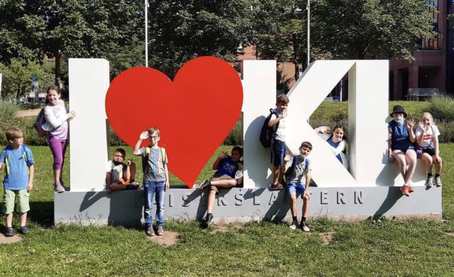 Auf dem Bild ist eine Gruppe vom Sommerferienprogramm an der neuen I Love KL-Statue zu sehen. © Stadt Kaiserslautern