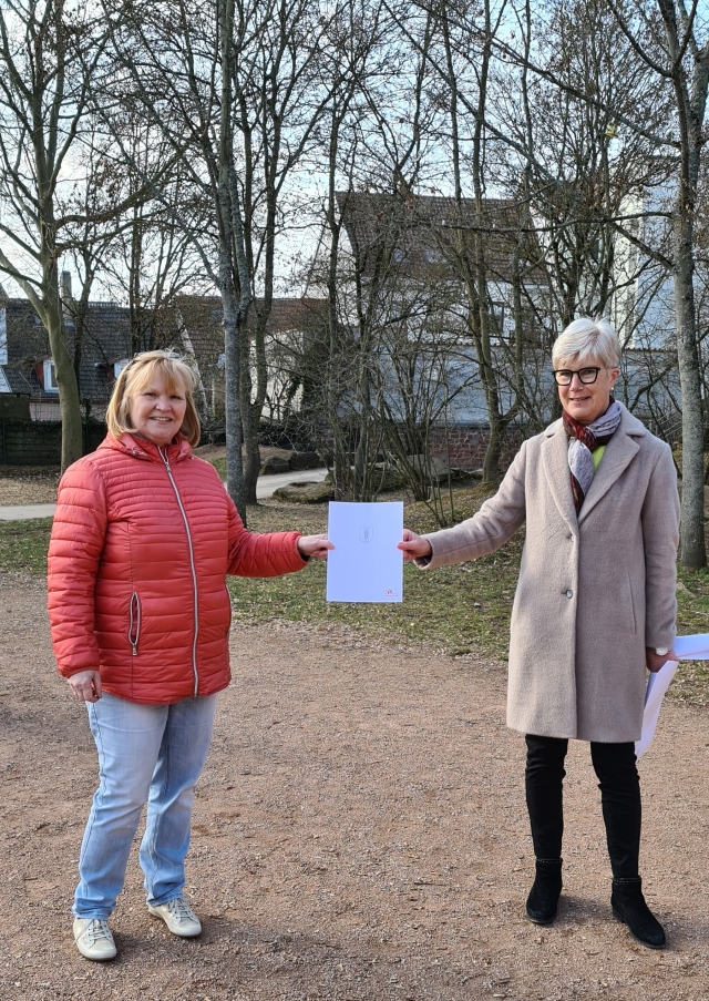 Auf dem Bild sieht man, wie Katharina Rothenbacher-Dostert, Referatsleiterin für Jugend und Sport, die Verabschiedungsurkunde der angehenden Ruheständlerin, Cornelia Thiel, übergibt. © Stadt Kaiserslautern