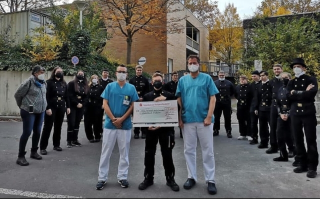 Auf dem Bild sieht man die Schornsteinfeger-Auszubildenden bei der Spendenübergabe vorm Westpfalz-Klinikum mit den Chefärzten der Kinderklinik. 