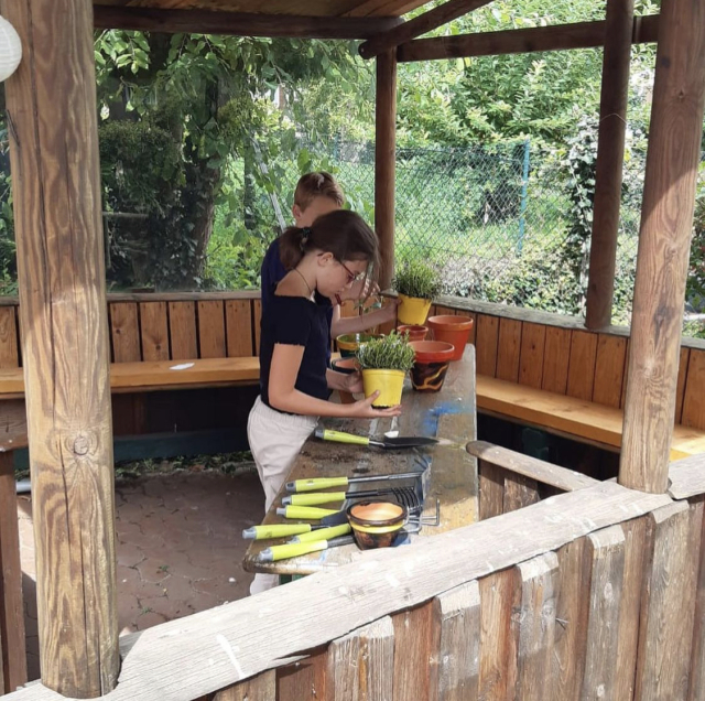 Auf dem Bild ist eine Gruppe vom Sommerferienprogramm zu sehen, die im Garten des Jugendhauses in der Auguststraße werkeln. © Stadt Kaiserslautern