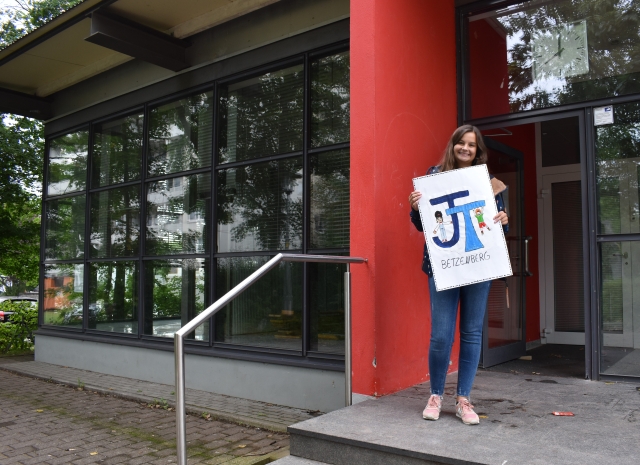 Auf dem Bild sieht man Sozialpädagogin Carla Schnellting mit dem von den Kindern designten Logo für den neuen Jugendtreff. © Stadt Kaiserslautern