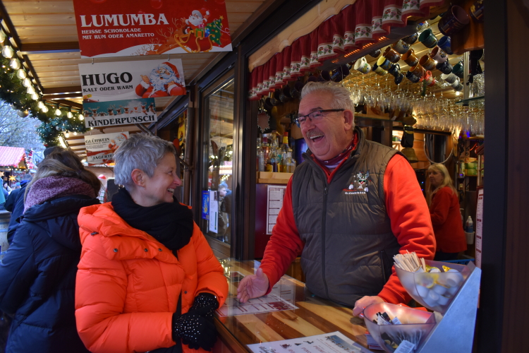 Beate Kimmel im Gespräch mit Karl Knörr an seinem Glühweinstand auf dem Weihnachtsmarkt. © Stadt Kaiserslautern