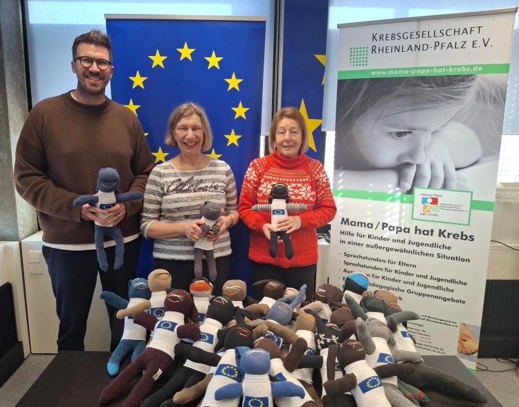 V.l.: Marco Zettl, Leiter von Europe Direct Kaiserslautern, Heidi Noichl, Mitarbeiterin von Europe Direct Kaiserslautern, und Ingrid Sander aus der Kreativgruppe des Fördervereins Mama/Papa hat Krebs Kaiserslautern präsentieren die Sockenhasen mit ihren Europa-Pullis. © Stadt Kaiserslautern