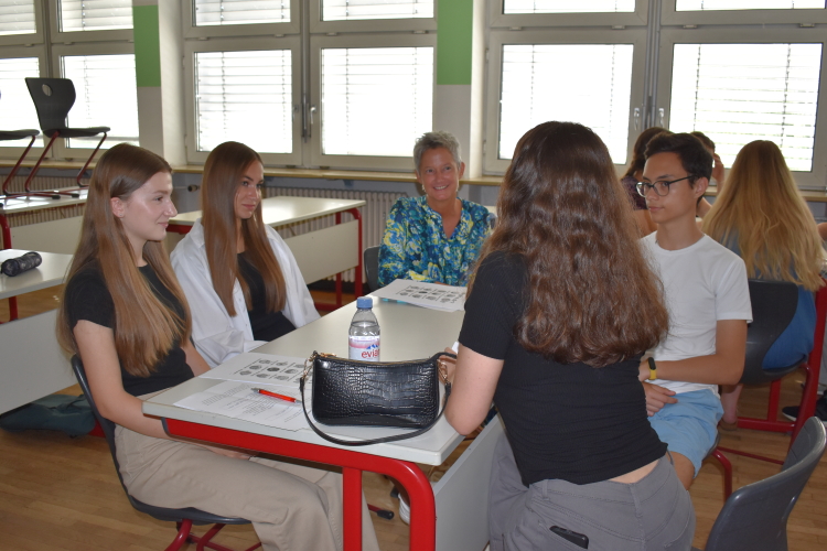 Bei ihrem Besuch setzte sich die Bürgermeisterin zu einer Gruppe dazu, die gerade mit spielerischen Mitteln deutsche Vokabeln lernte.  © Stadt Kaiserslautern