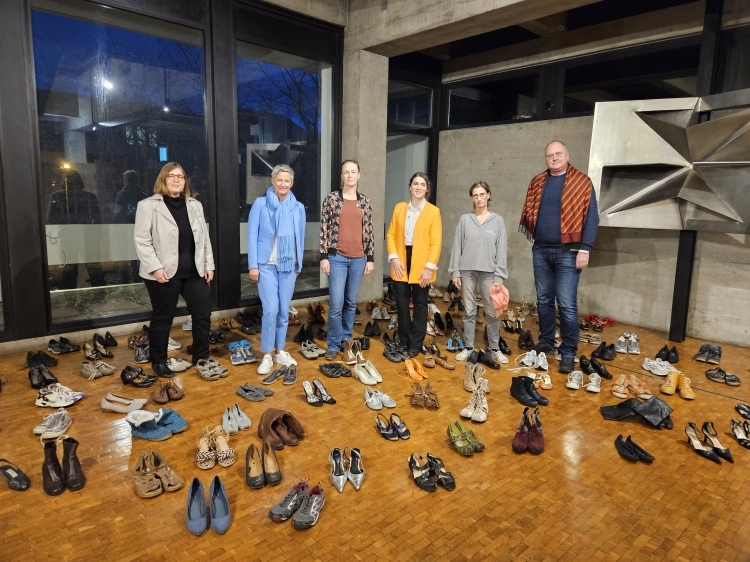 Die Veranstaltung wurde mitgestaltet von Meike Camby, Beate Kimmel, Katharina Disch, Rabia Gülsen Atasoy, Claudia Kettering und Richard Hackländer. Die Gruppe steht inmitten der vielen Schuhpaare im Rathausfoyer, die die Opfer von Gewalt symbolisieren. © Stadt Kaiserslautern