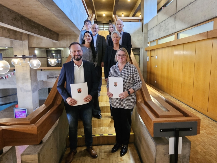 Udo Fischer und Martina Flett mit den überreichten Urkunden und ihren Gratulantinnen und Gratulanten. © Stadt Kaiserslautern