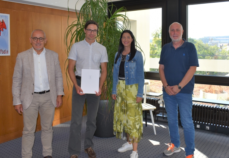 Auf dem Bild ist Jan Hastrich mit Anja Pfeiffer (Beigeordnete) sowie Ludwig Steiner (Referatsleiter für Jugend und Sport) und Peter Schmitt (Personalratsvorsitzender) bei der Ernennung zu sehen.  Stadt Kaiserslautern