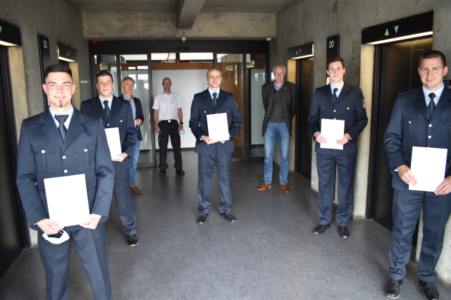 Vorne im Halbkreis: die fünf jungen Lebenszeitbeamten der städtischen Feuerwehr. Hinten vlnr: Wolfgang Mayer, Thomas Höhne, Beigeordneter Peter Kiefer  © Stadt Kaiserslautern