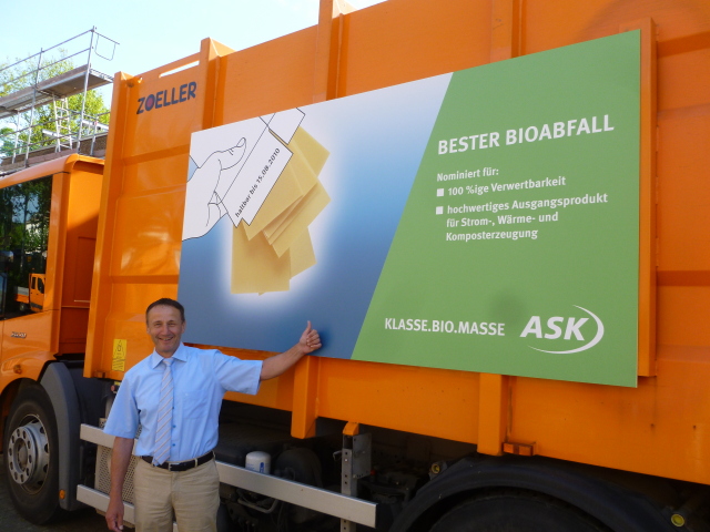 ASK-Werkleiter Rainer Grüner vor einem Müllfahrzeug mit neuem Plakat. © Stadt Kaiserslautern