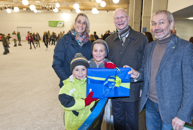 Freute sich riesig über sein Geschenk: Philipp (vorne links) mit seiner Mama und seinem Bruder Florian bekam als 10.000ster Besucher der diesjährigen Eisbahnsaison von Beigeordnetem Joachim Färber (2. v. r.) und Ortwin Kafitz von der SWK eine 12er-Eintrittskarte und ein Monopoly Kaiserslautern Brettspiel überreicht.  © View