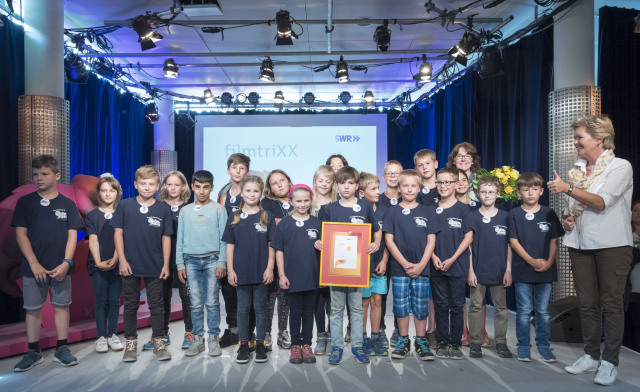 Klasse 3 der Grundschule Erzhütten in Kaiserslautern mit
SWR-Landessenderdirektorin Simone Schelberg und Lehrerin Birgit Kopnarski –
ihr Film trägt den Titel „Die, die auszogen, um das Glück zu finden“; SWR/ Stefan F. Sämmer