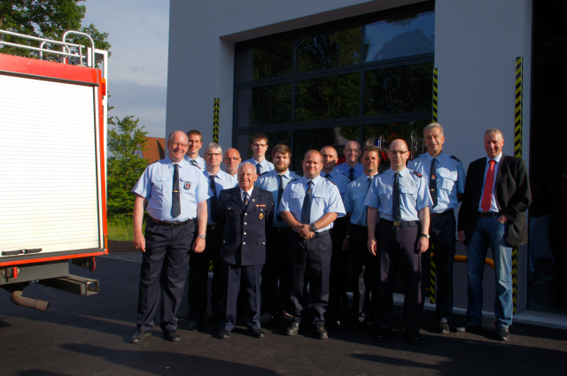 Feuerwehrdezernent Peter Kiefer (rechts im Bild) mit dem Zug der Freiwilligen Feuerwehr Erlenbach vor dem neuen Feuerwehrgerätehaus. © Stadt Kaiserslautern