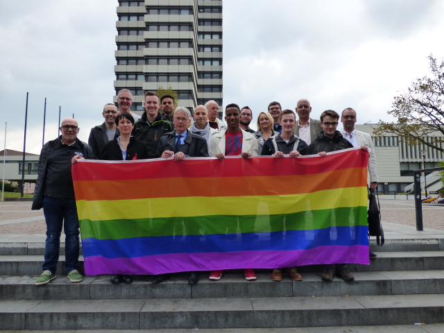 Mit der symbolischen Flaggenübergabe an die Schirmherren Klaus Weichel und Raphael Holzdeppe (erste Reihe, 3.v.l. und 4. v.l.) startete heute offiziell die Aktion Prideweek KL.  © Stadt Kaiserslautern