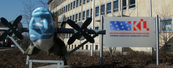 Das rathaus Nord mit dem internationalen Fliegerfisch, dem Deutsch-Amerikanischen Bürgerbüro Schild und gehissten Flaggen deutscher und amerikanischer Nationalität. 