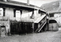 Der Innenhof des heutigen Theodor-Zink-Museums ist stark von der Zeit gezeichnet. Der Putz gibt das Mauerwerk frei, die Holztore haben tiefe Kerben und Löcher. Eine Wäscheleine ist über den Hof gespannt.