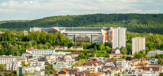 Fritz-Walter-Stadion mit der Stadt im Vorder- und dem Wald im Hintergrund.