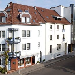 Die weiße und freundliche Außenfassade mit dem Efeu, was über die Eckbalkone bis in den zweiten Stock kletter geben dem Hotel Zollamt ein uriges Aussehen.