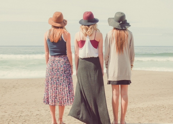 Frauen am Strand in luftiger Kleidung.
